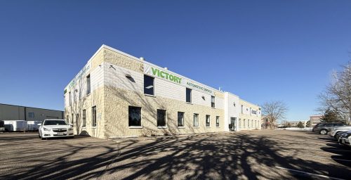 Victory Automotive Service building exterior with parking lot and blue sky background.
